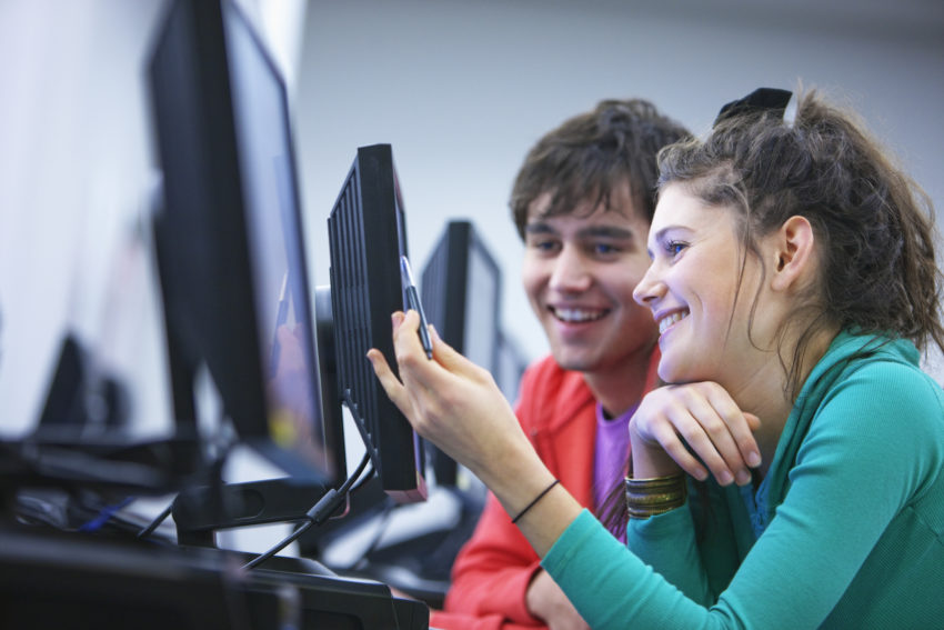 Side View Of Two Young University Students,Using,Computers